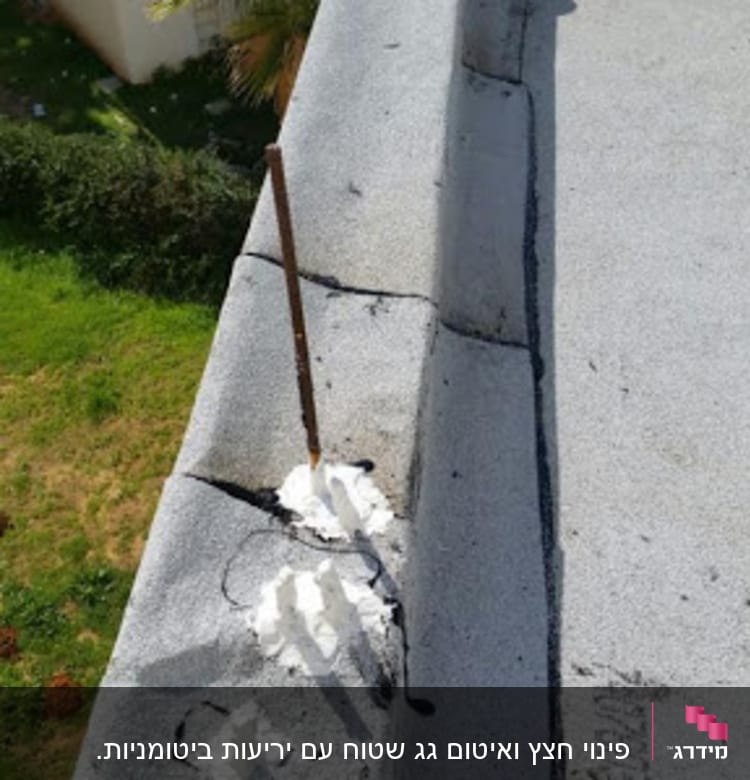 חומר איטום לבן על גג בטון עם מוט ברזל